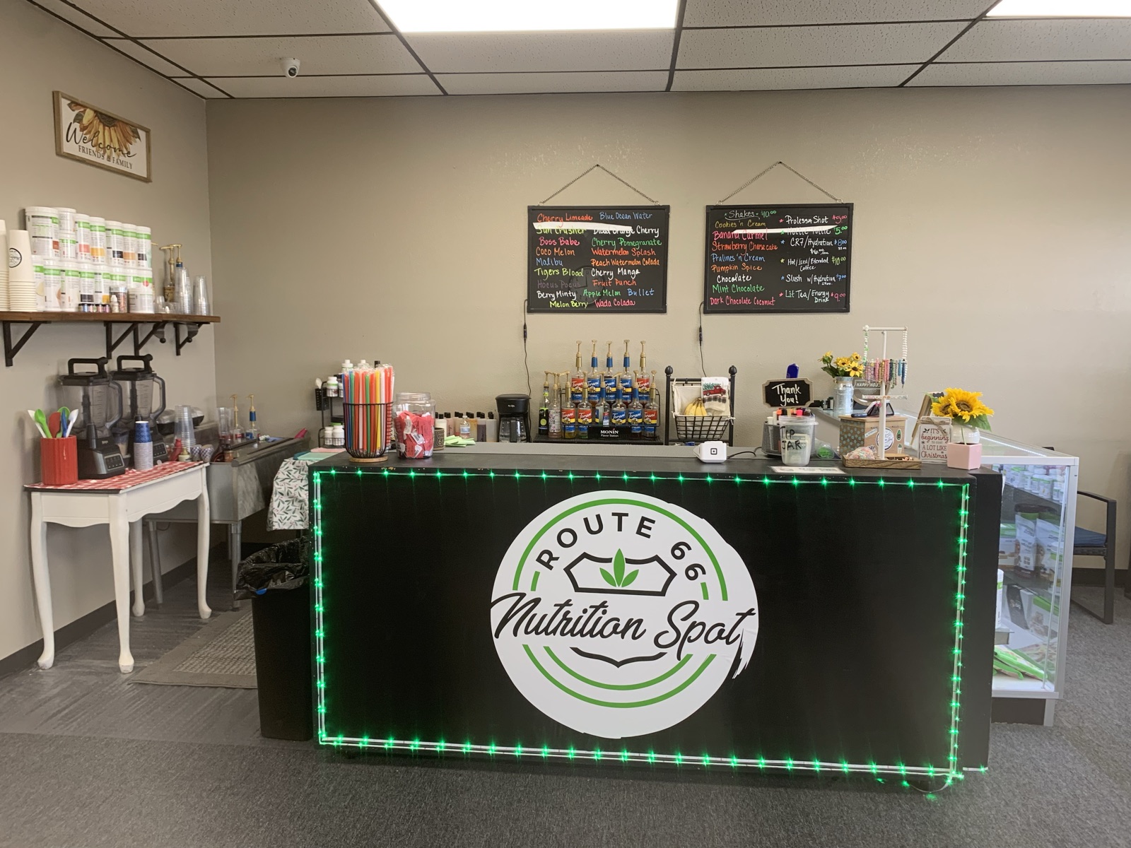 Inside Route 66 Nutrition Spot in Winslow, AZ — neon-lit counter and menu boards